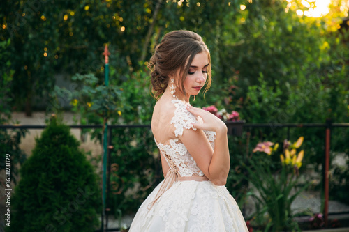 Young girl in wedding dress in park posing for photographer. portrait © Aleksandr