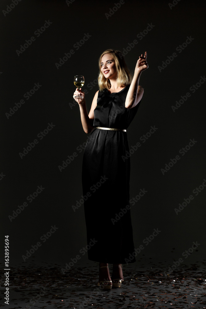 Beautiful blonde woman with glass of white wine on black background Beautiful blonde woman with glass of white wine on black background