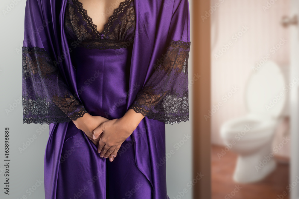 The woman in  purple satin sleepwear and robe wake up for go to restroom. People with urinary bladder problem concept