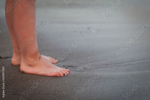 Children legs on a beach