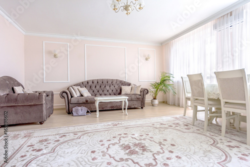 White apartment interior design living room with classic furniture, sofa and white table, flower and tv audio set, modern style in chisinau, cenral district, moldova photo