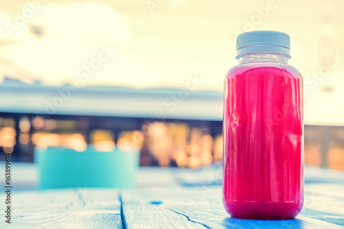 Plastic bottle with red fruit drink in restaurant photo