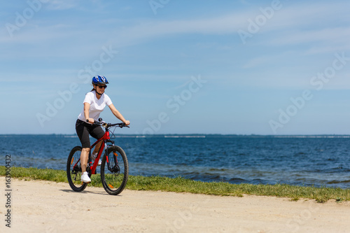 Woman cycling at seaside 