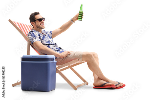 Tourist sitting in a deck chair and toasting with beer © Ljupco Smokovski