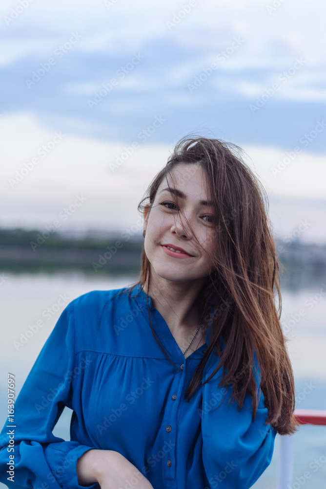 Summer happy portrait beautiful woman girl caucasian asian blended in blue shirt posing on background sky lake water sunset long hair brunette outdoors Summer happy portrait beautiful woman girl caucasian asian blended in blue shirt posing on background sky lake water sunset long hair brunette outdoors