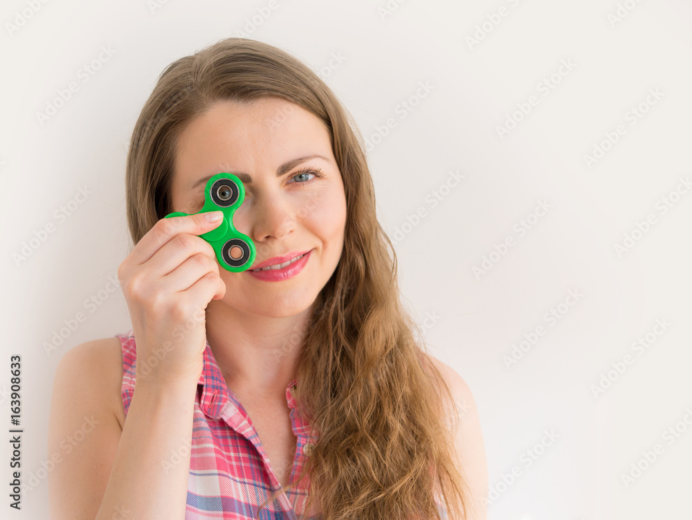 Girl playing with a colourful hand fidget spinner toy Girl playing with a colourful hand fidget spinner toy