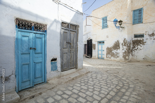 street with blue door and broken wall in Tunisia © sergejson