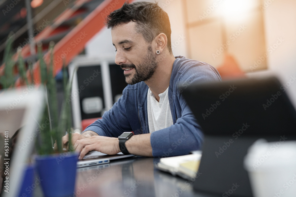 Fototapeta premium Man working in coworking office on laptop