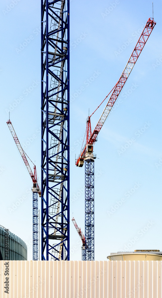 Four tower cranes on a construction site in the middle of a business district in full development. Four tower cranes on a construction site in the middle of a business district in full development.