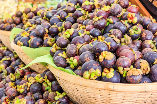 Fresh mangosteen queen of fruits (Garcinia mangostana Linn) in the basket at supermarket, healthy purple mangosteen fruit food photo