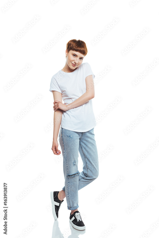 Attractive young woman in white t-shirt and denim pants looking at camera isolated on white Attractive young woman in white t-shirt and denim pants looking at camera isolated on white