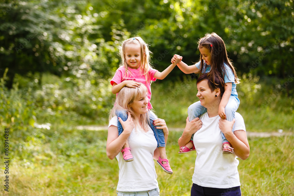 Obraz premium Two mothers and two small daughters in the park