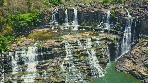 Flycam Hangs above Narrow Waterfalls Pongour Running from Rocks photo