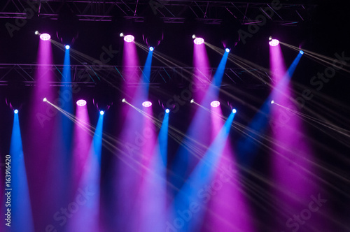 Stage lights on concert. Lighting equipment with multicolored beams.