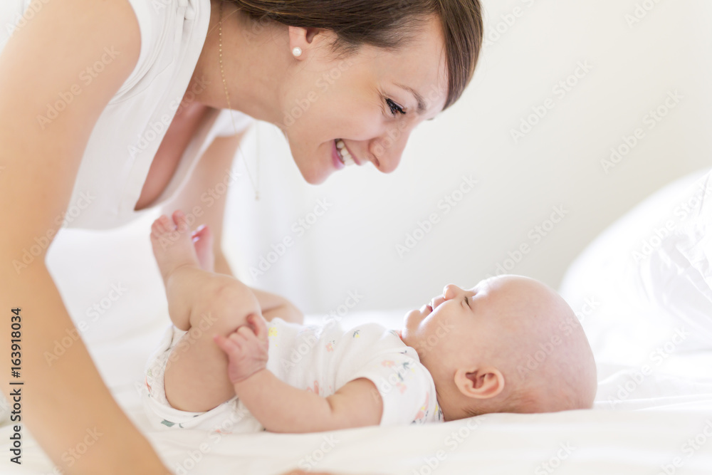 Portrait of mother with her 3 month old baby in bedroom Portrait of mother with her 3 month old baby in bedroom