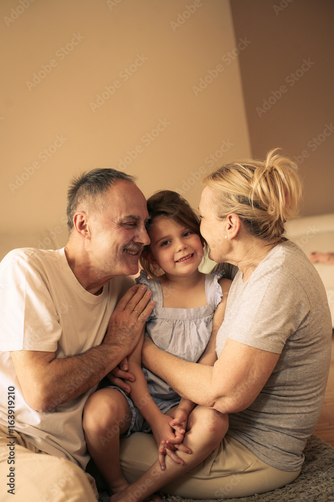 Fototapeta premium Playful grandparents with their granddaughter.