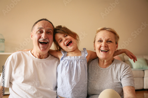 Playful grandparents with their granddaughter. photo