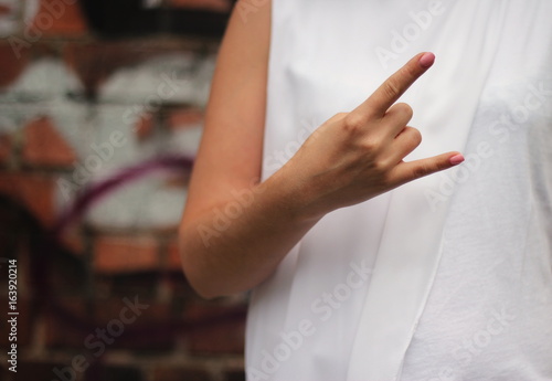 Young woman s hands shows rock gesture.