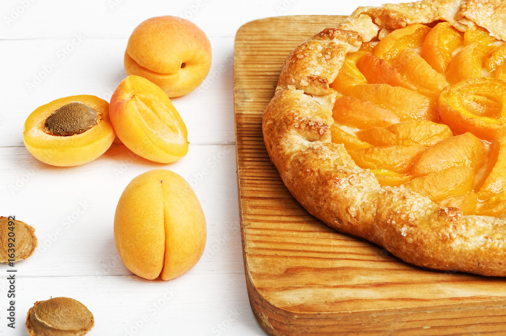 Homemade biscuit pie with peaches and fresh yellow peaches on white wooden table. Homemade biscuit pie with peaches and fresh yellow peaches on white wooden table.