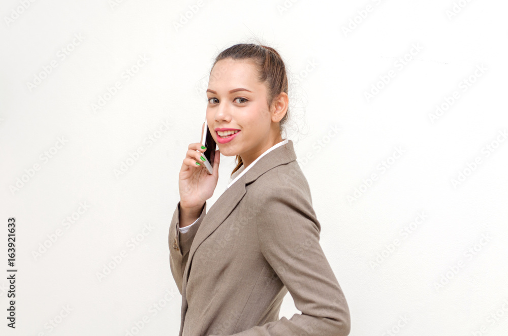 portrait of asian young beautiful smiling business woman standing and talking on her mobile smartphone isolated on white background, business and technology concept portrait of asian young beautiful smiling business woman standing and talking on her mobile smartphone isolated on white background, business and technology concept