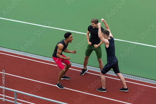 Happy multiethnic athlete team make winner gesture © Drobot Dean