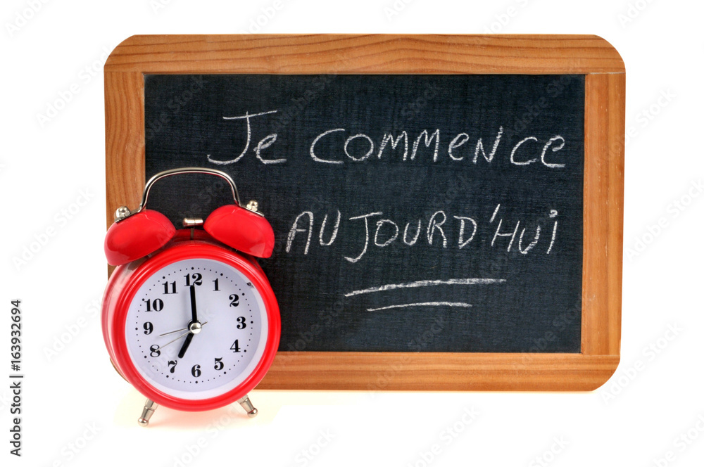 Je commence aujourd'hui écrit sur une ardoise avec un réveil-matin Je commence aujourd'hui écrit sur une ardoise avec un réveil-matin