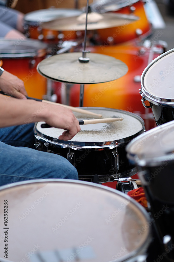 The drummer's hands with a stick behind the drum set. Baltic Drum Summit 2017. Riga, Latvia. The drummer's hands with a stick behind the drum set. Baltic Drum Summit 2017. Riga, Latvia.