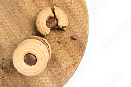 Flat lay crisp biscuits topped with chocolate cream on the wooden board