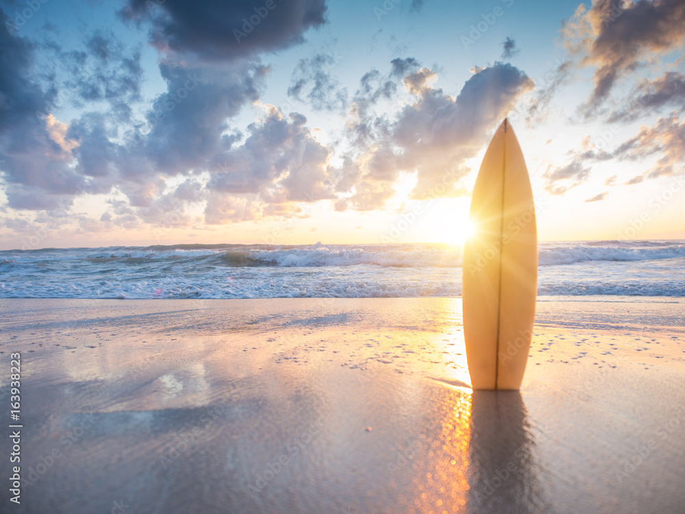 Surfboard on the beach at sunset - obrazy, fototapety, plakaty 