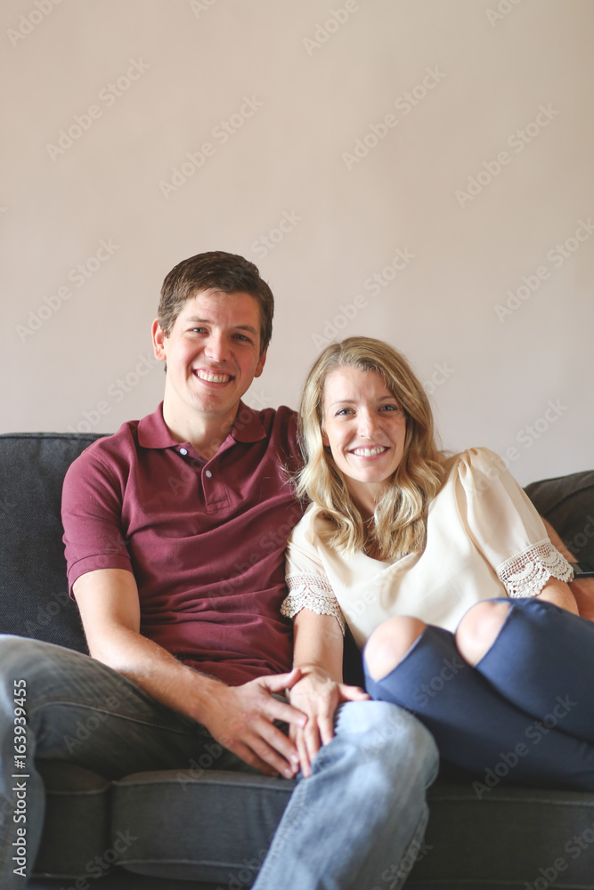 Beautiful couple sit together on couch