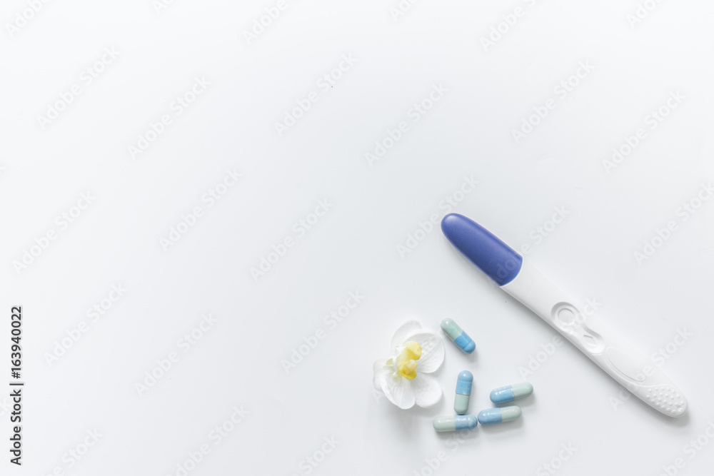 Pregnancy planning. Pregnancy test and pills on white background top view copyspace Pregnancy planning. Pregnancy test and pills on white background top view copyspace
