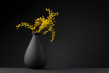 yellow flower on the black vase