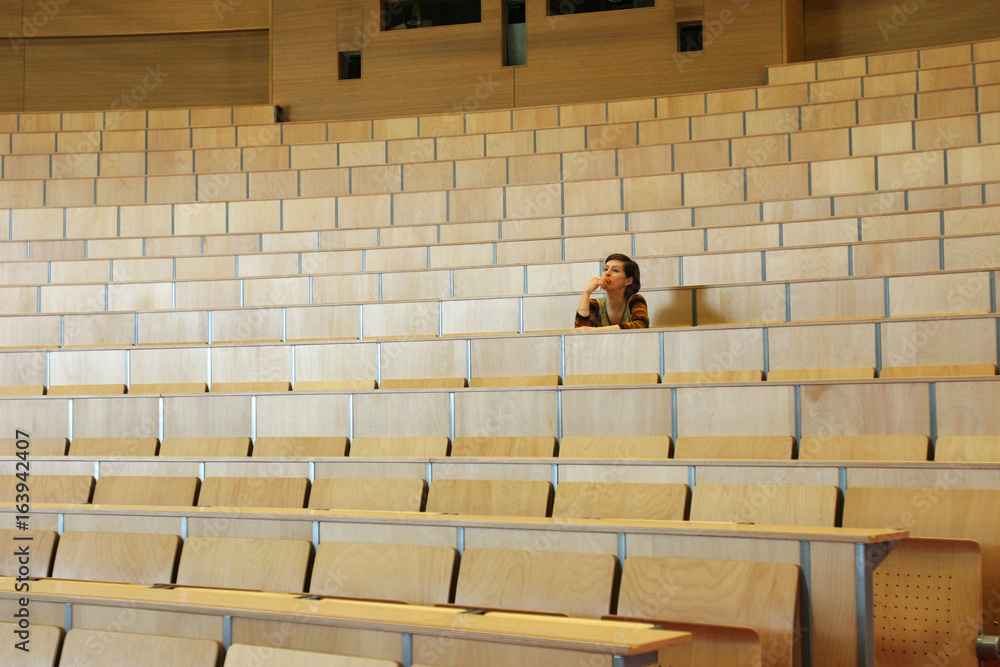 Naklejka premium Studentin in einem leeren Hörsaal in einer Universität