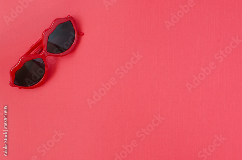 Red sunglasses. Red background