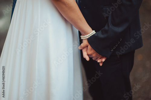 Holding hands. Closeup view of married couple holding hands