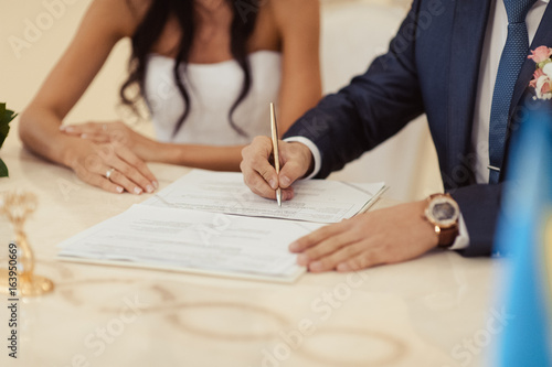 Signature Ceremony. The bride and groom sign the documents about the marriage