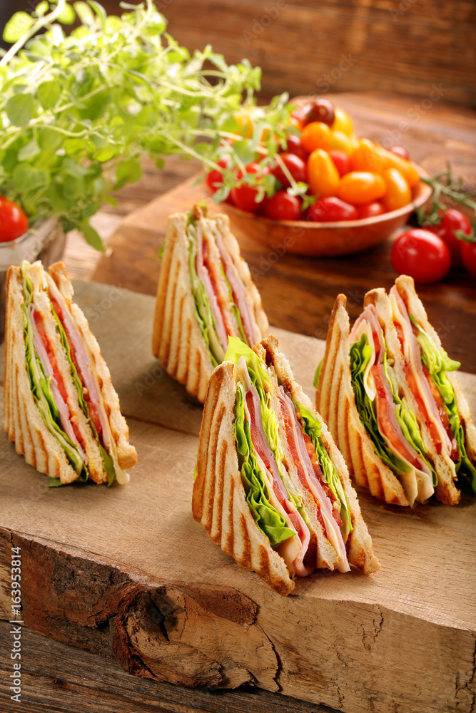 Fresh four sandwiches on wooden background
