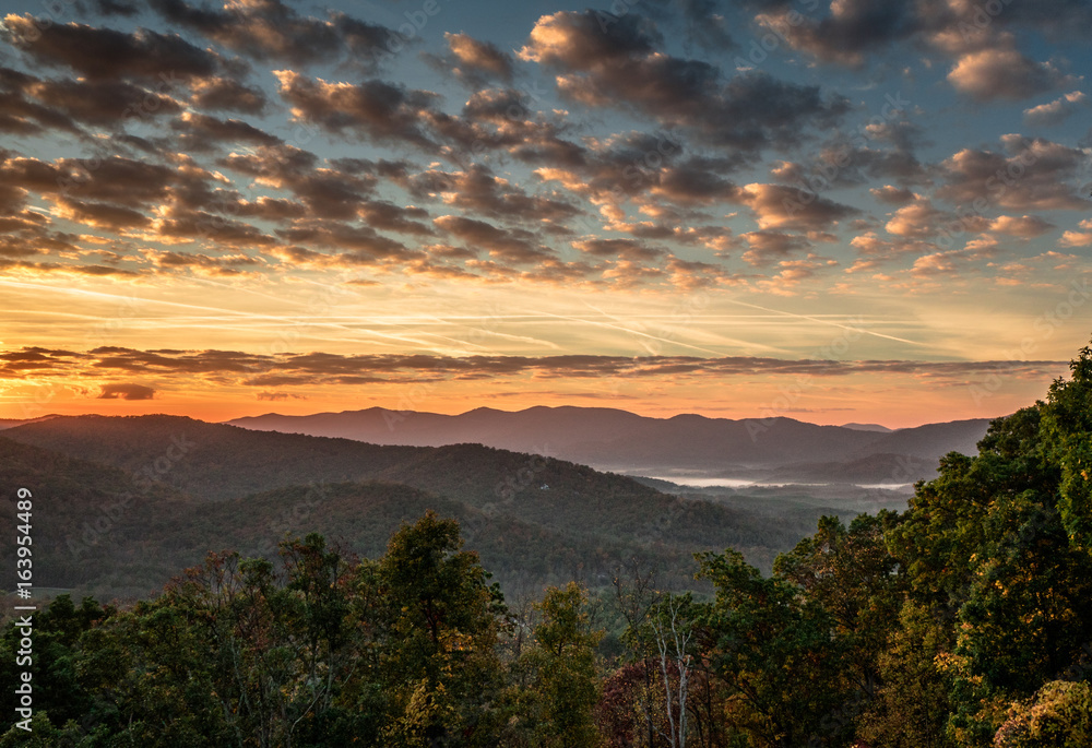 beautiful morning and sunrise over the Blue Ridge mountains in the North Carolina Appalachians with misty valleys and an expressive and colorful sky with clouds