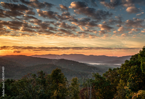 beautiful morning and sunrise over the Blue Ridge mountains in the North Carolina Appalachians with misty valleys and an expressive and colorful sky with clouds