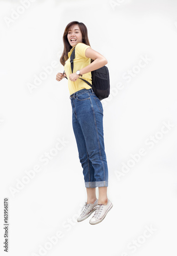 asian teenage girl jump ping with backpack photo