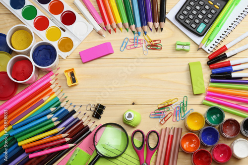 school and office supplies. school background. colored pencils, pen, pains, paper for school and student education on wooden background. top view with copy space