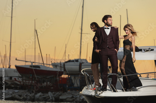 Stylish wealthy friends having fun on a luxury yacht
