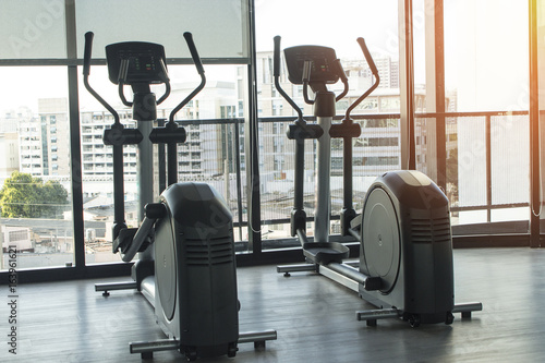 Healthy lifestyle fitness concept with bike machines in the gym and a training for lifestyle concept cardio, endurance, and weight loss with high contrast and monochrome.