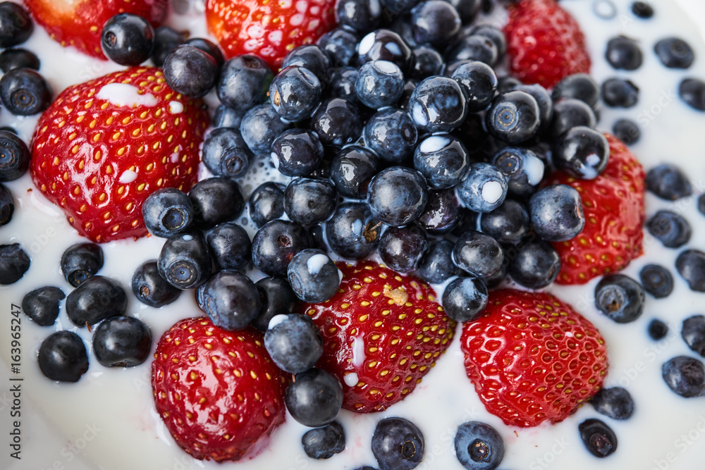 Strawberries, blueberries and milk in a white bowl Strawberries, blueberries and milk in a white bowl