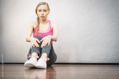 Sad depressed young teenage girl sitting by wall