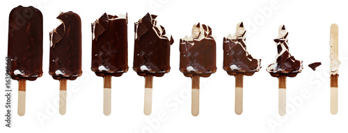 Progression of chocolate covered vanilla ice cream bars on a wooden stick with bites taken out. Isolated over a white background.