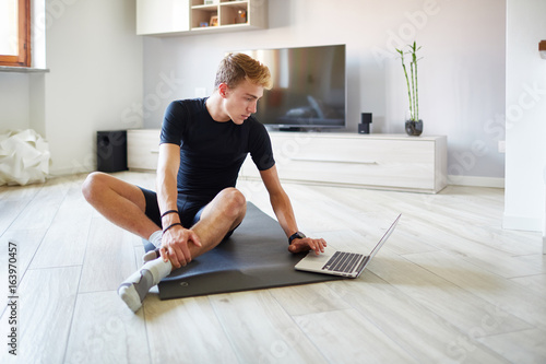 Ragazzo in soggiorno cerca esercizi al pc