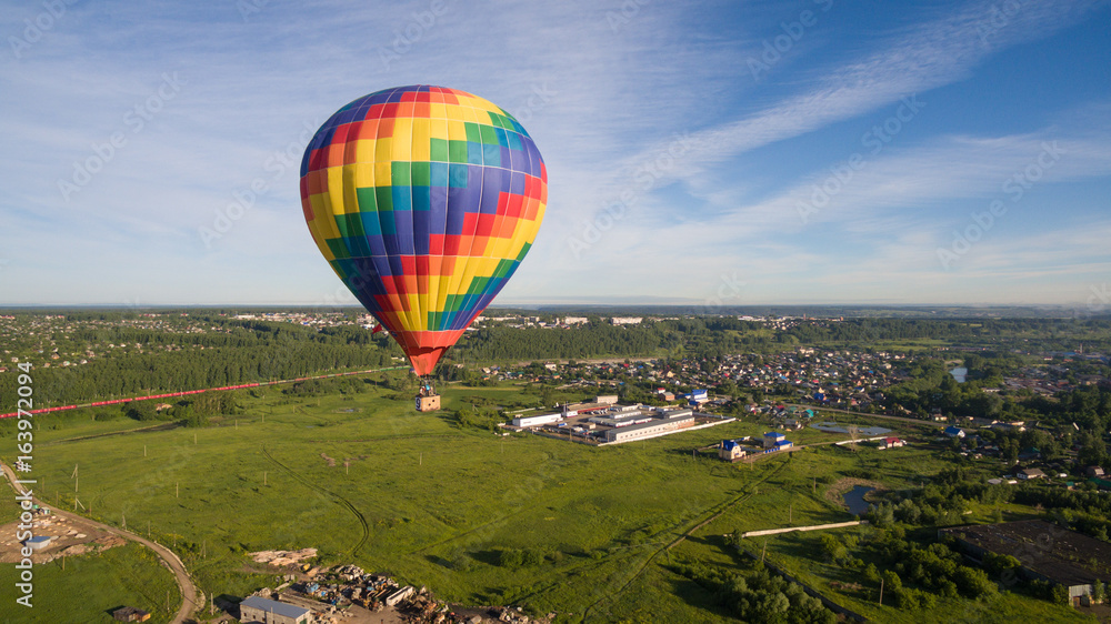 Obraz premium Rainbow aerostat over village aerial view