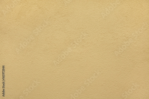 Yellow ochre painted stucco wall. Background texture