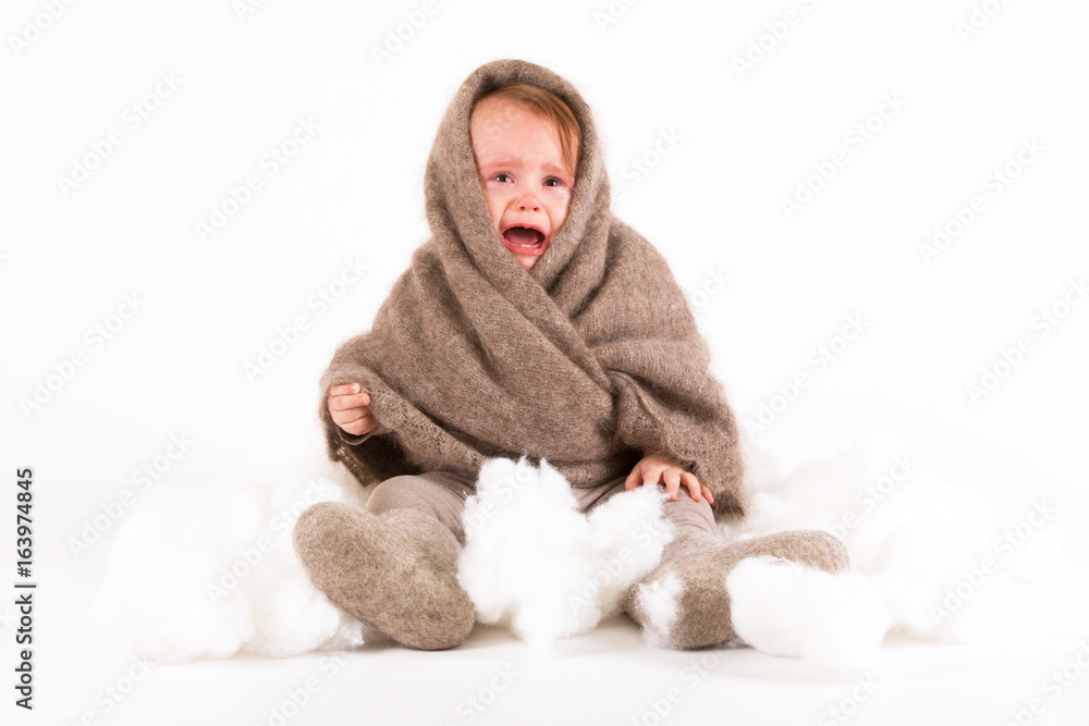 Cute baby girl in a woolen shawl and boots on white background Cute baby girl in a woolen shawl and boots on white background